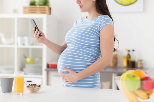 Primer plano de la mujer embarazada utilizando el teléfono inteligente —  Fotos de Stock