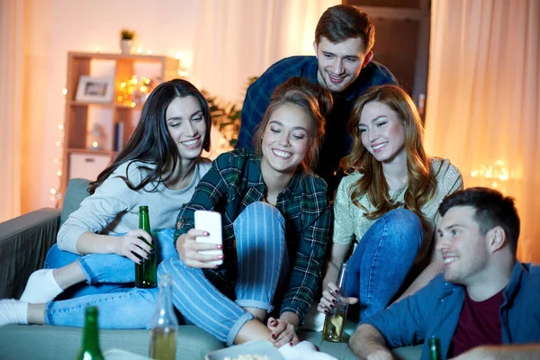 Amigos felices con teléfono inteligente en la fiesta en casa —  Fotos de Stock