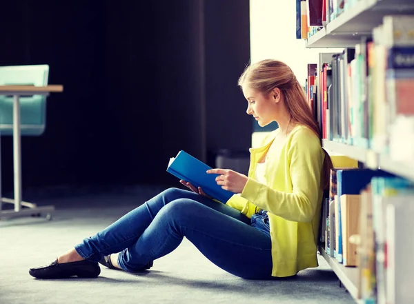 Gymnasiastin liest Buch in Bibliothek — Stockfoto