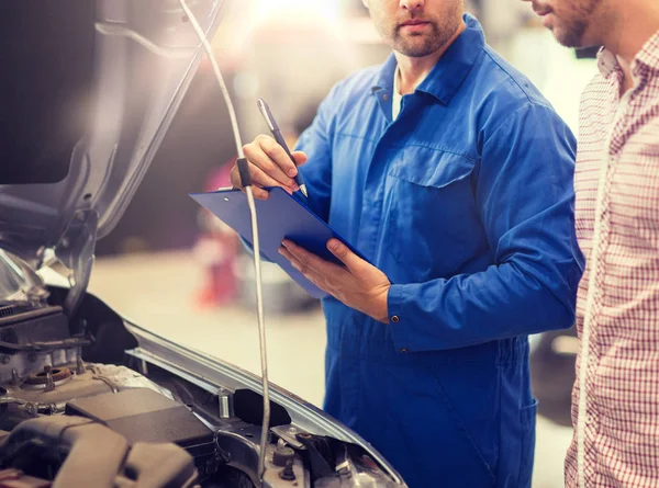 Auto monteur met klembord en man bij de auto-shop — Stockfoto