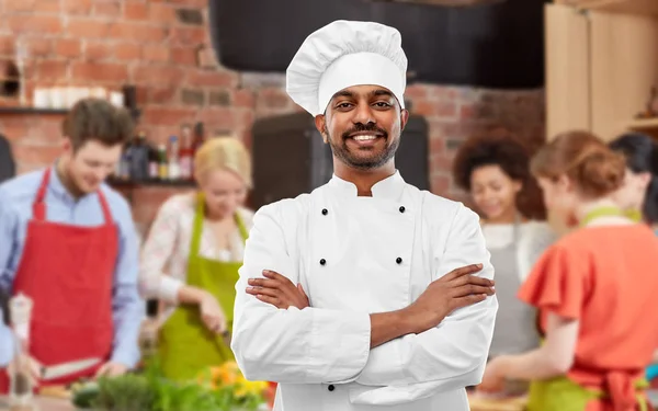 Happy male indian chef in toque at cooking class — Stock Photo, Image