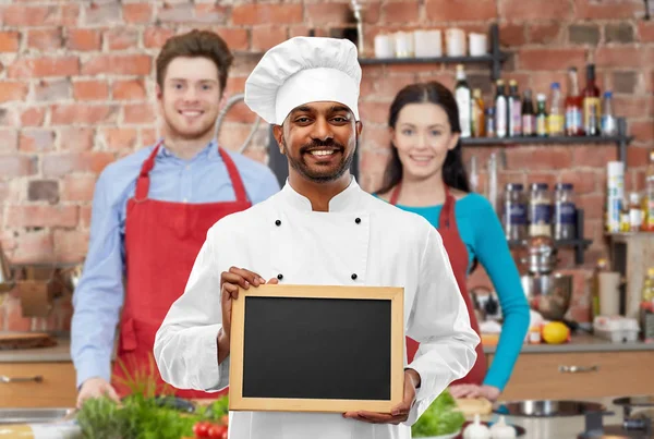 料理教室で黒板を持つ幸せなインドのシェフ — ストック写真