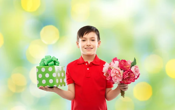 Niño sonriente con caja de regalo de cumpleaños y flores —  Fotos de Stock