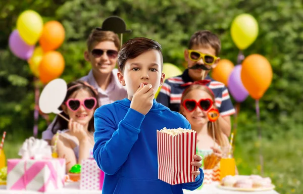 Chłopiec jedzenia popcorn na przyjęcie urodzinowe — Zdjęcie stockowe