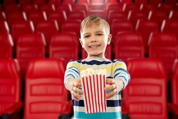 Jongen met papieren emmer popcorn in bioscoop — Stockfoto