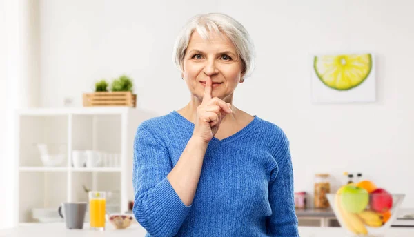 Senior nő hogy elhallgattat gesztus a konyhában — Stock Fotó