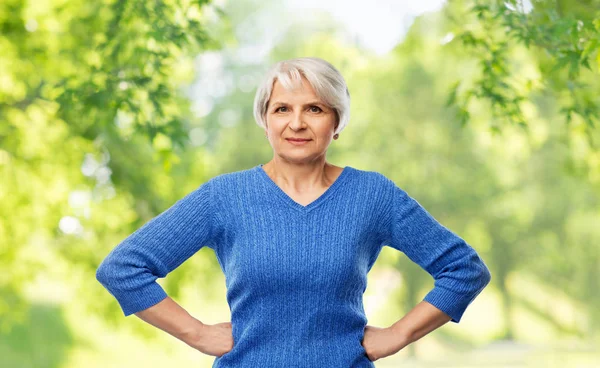 Donna anziana in maglione blu mani sui fianchi — Foto Stock