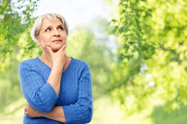 Anziana donna pensando su sfondo naturale — Foto Stock