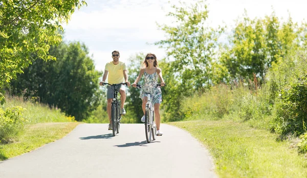 Happy young couple riding bicycles in summer — Stock Photo, Image