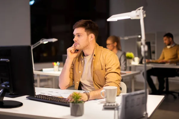 Hombre llamando en el teléfono inteligente en la oficina de noche — Foto de Stock