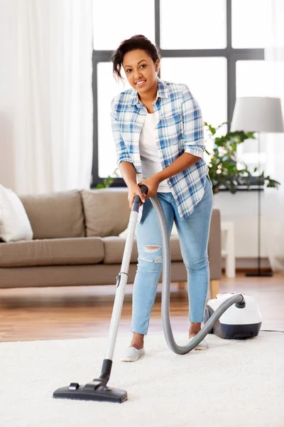 Femme ou femme au foyer avec aspirateur à la maison — Photo