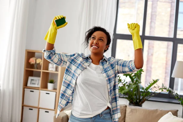 Happy african woman with sponge cleaning at home — Stock Photo, Image