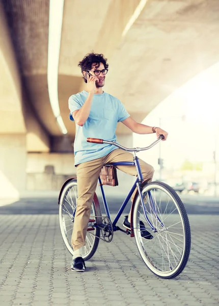 Hombre con teléfono inteligente y bicicleta de engranaje fijo en la calle —  Fotos de Stock