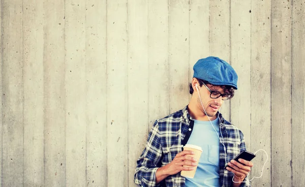 Hombre con auriculares y teléfono inteligente beber café —  Fotos de Stock