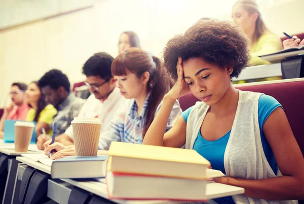 Grupp studenter med kaffe skriva på föreläsning — Stockfoto