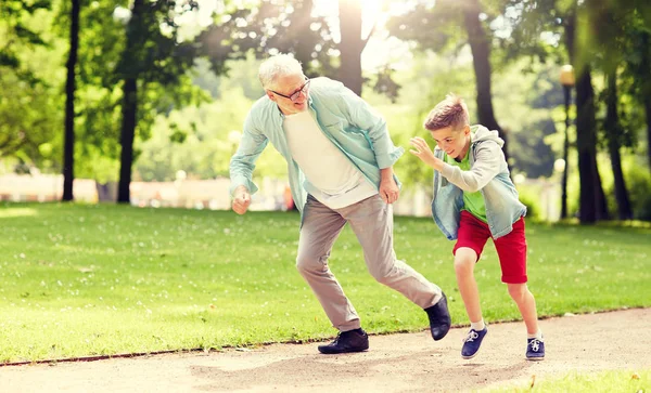 Abuelo y nieto corriendo en el parque de verano — Foto de Stock