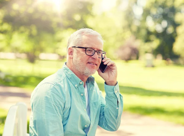 Hombre mayor llamando en el teléfono inteligente en el parque de verano —  Fotos de Stock