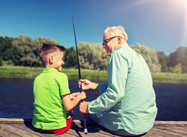 Grandfather and grandson fishing on river berth — Stock Photo, Image