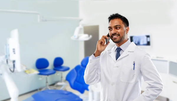 Dentysta dzwoniąc na smartphone w klinice stomatologicznej — Zdjęcie stockowe
