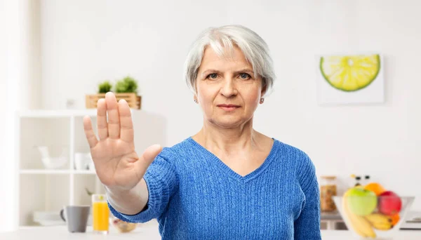 Mujer mayor haciendo gesto de parada en la cocina — Foto de Stock
