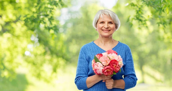 Boldog mosolygó idős asszony virágokkal — Stock Fotó