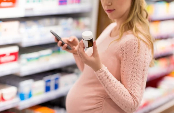 Mujer embarazada elegir la medicina en la farmacia — Foto de Stock