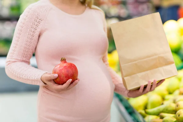 Kobieta w ciąży z torby zakup owoców o sklep spożywczy — Zdjęcie stockowe