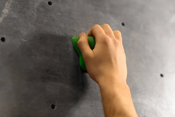 Mano maschile tenuta alla parete di arrampicata al coperto — Foto Stock