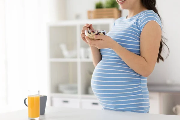 Zwangere vrouw die fruit muesli thuis eet — Stockfoto