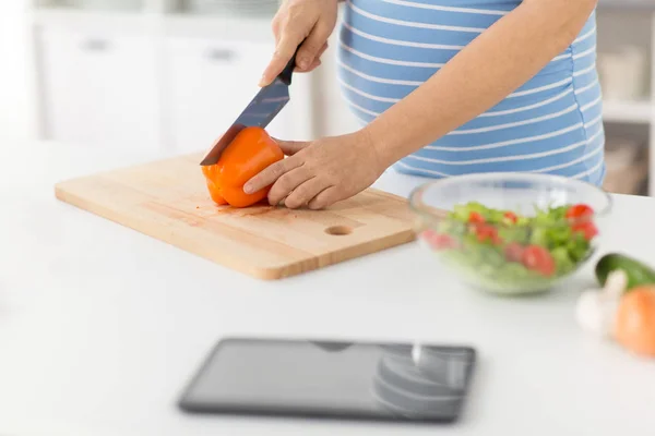 Pregnant woman cooking vegetable salad at home — Stock Photo, Image