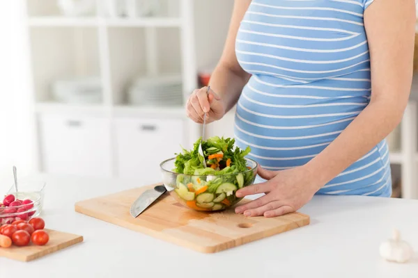 Primer plano de la mujer embarazada cocinar ensalada en casa — Foto de Stock