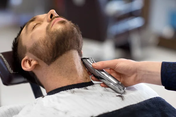 Homem e barbeiro com barba de corte aparador no salão — Fotografia de Stock