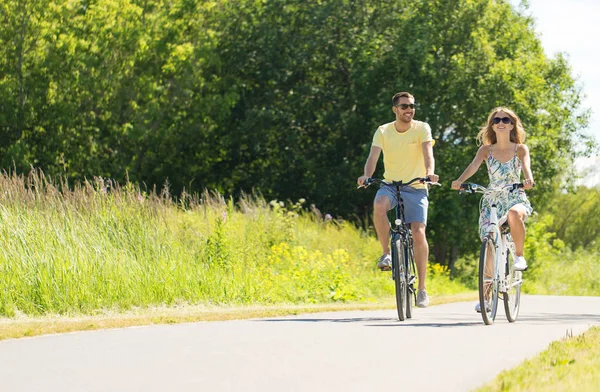 Happy young couple riding bicycles in summer — Stock Photo, Image