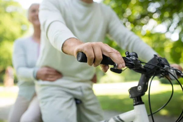 Felice coppia di anziani in sella a una bicicletta al parco — Foto Stock