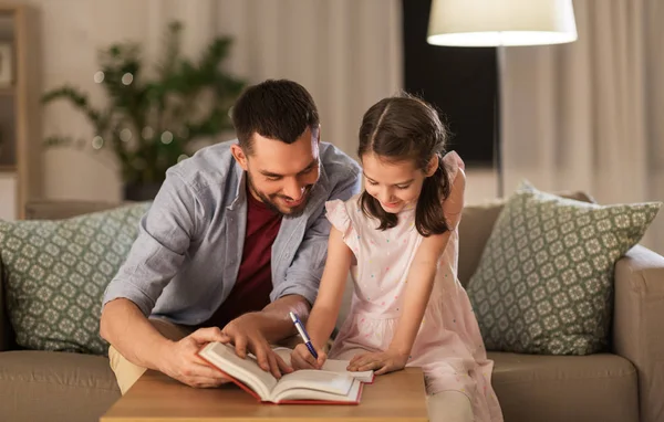 Father and daughter doing homework together — Stock Photo, Image