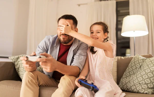 Père et fille jouer à un jeu vidéo à la maison — Photo