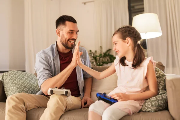 Pai e filha jogando videogame em casa — Fotografia de Stock