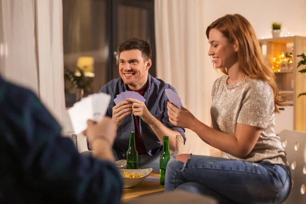Friends playing cards and drinking beer at home — Stock Photo, Image