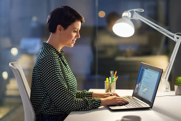 Mujer de negocios que trabaja en el ordenador portátil en la oficina de noche — Foto de Stock