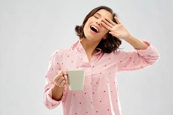 コーヒーとパジャマで幸せなあくび若い女性 — ストック写真