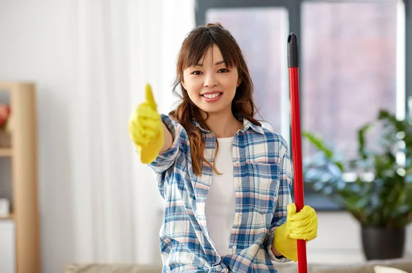 Asiático mujer limpieza casa y mostrando pulgares hasta — Foto de Stock