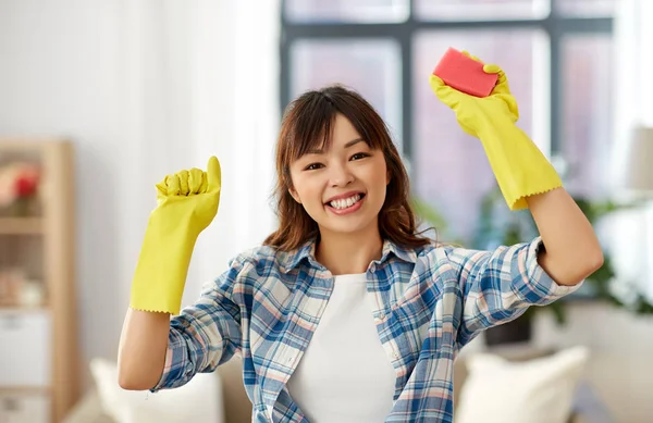 Feliz asiático mujer con esponja limpieza en casa —  Fotos de Stock