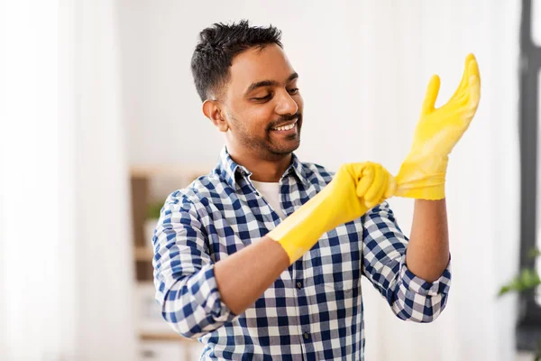 Indian man putting protective rubber gloves on — Stock Photo, Image