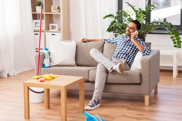 Homem chamando no smartphone depois de limpar casa — Fotografia de Stock