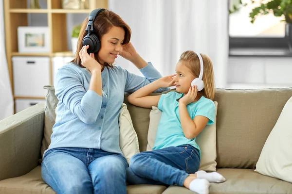 Mother and daughter in headphones listen to music — Stock Photo, Image
