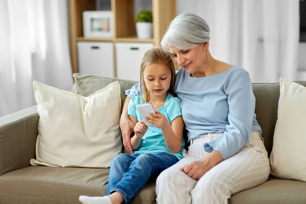 Grandmother and granddaughter with smartphone — Stock Photo, Image