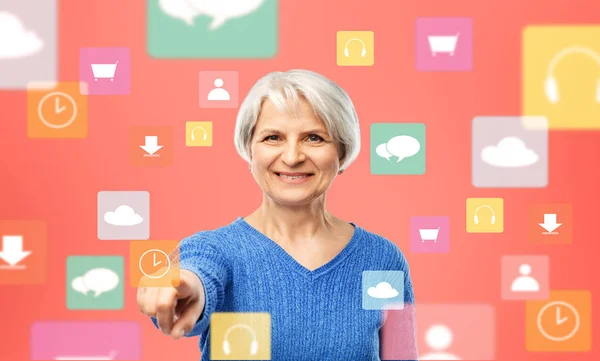 Mujer mayor apuntando al icono del reloj de la aplicación móvil —  Fotos de Stock