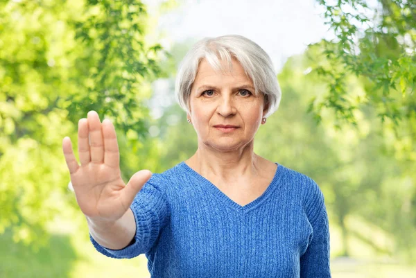 Starší žena v modrém svetru se gestem stop — Stock fotografie