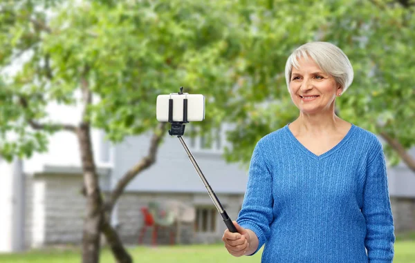 Lächelnde Seniorin macht Selfie mit dem Smartphone — Stockfoto
