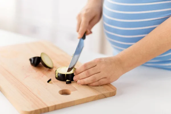 Закрыть беременную женщину, которая готовит еду дома — стоковое фото